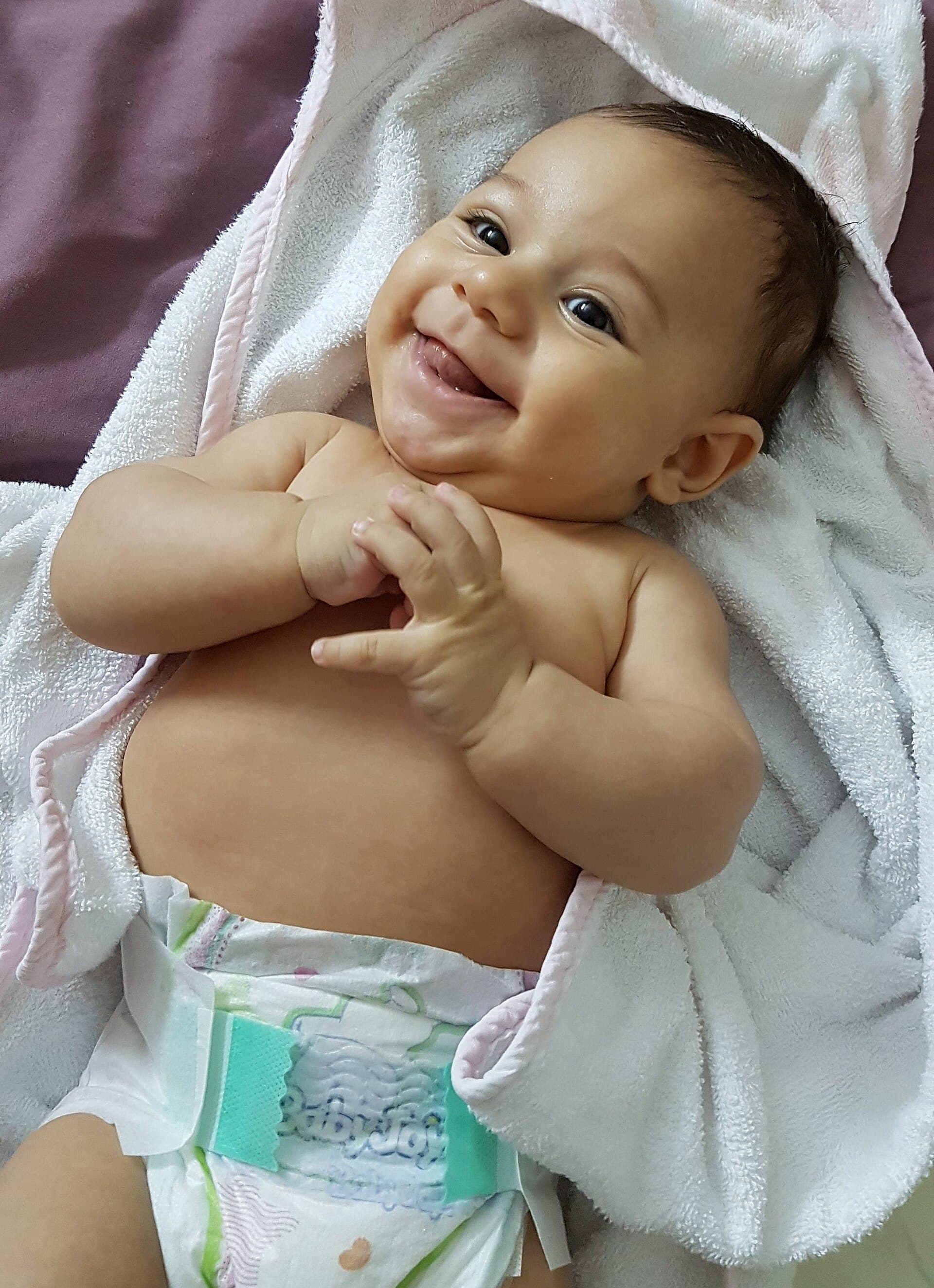 Blije baby op een handdoek (stockfoto)